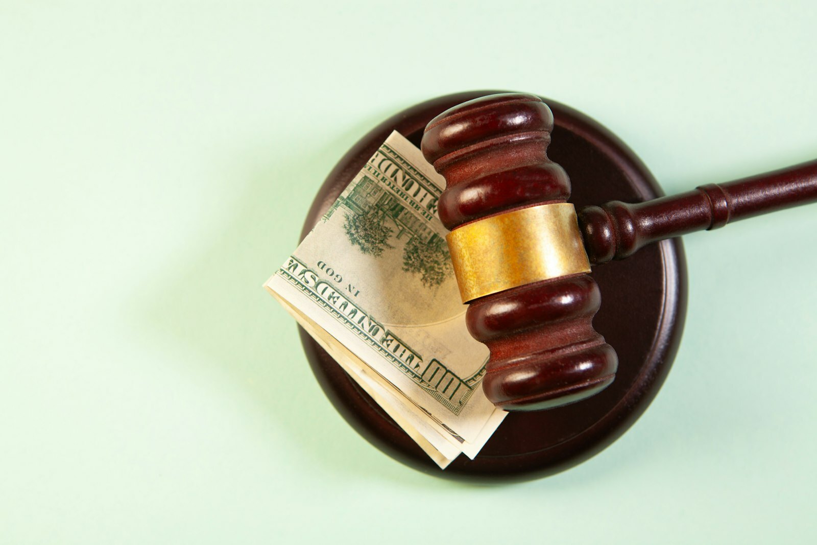 A gavel rests on a sound block with money