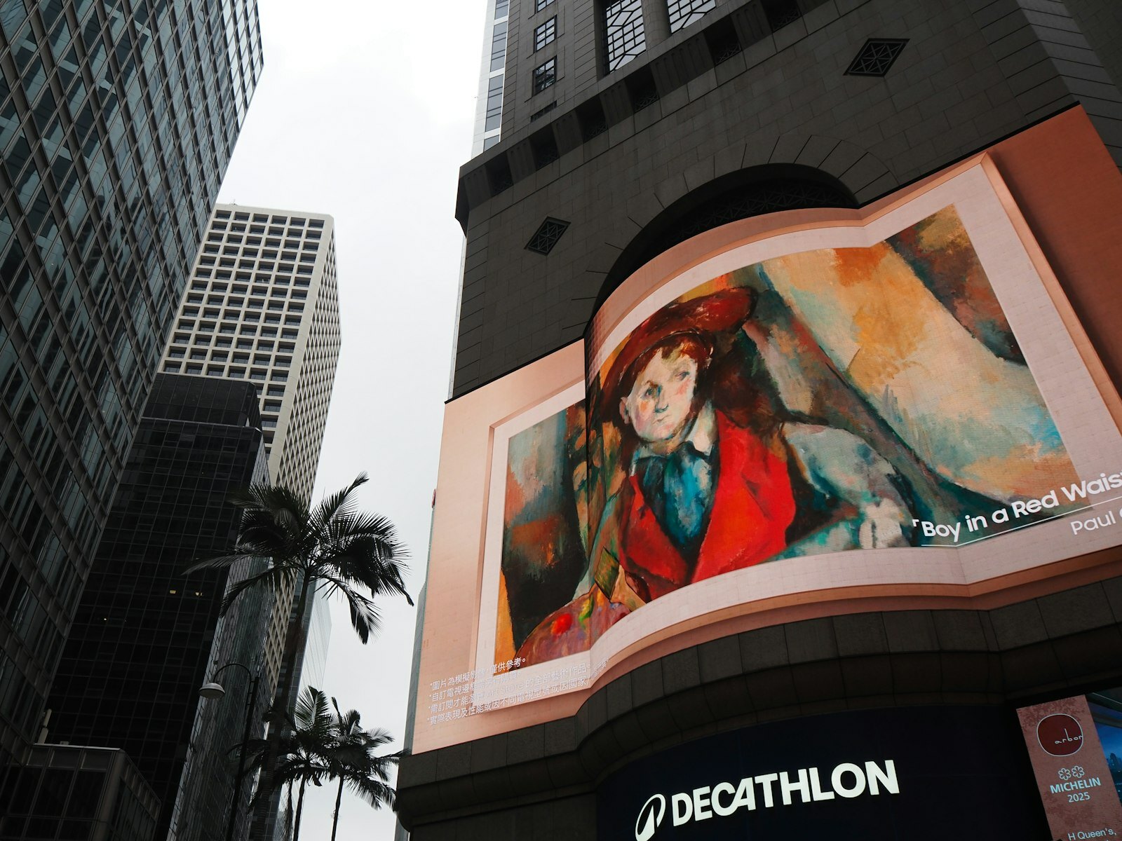 Artwork displayed on a building facade with skyscrapers
