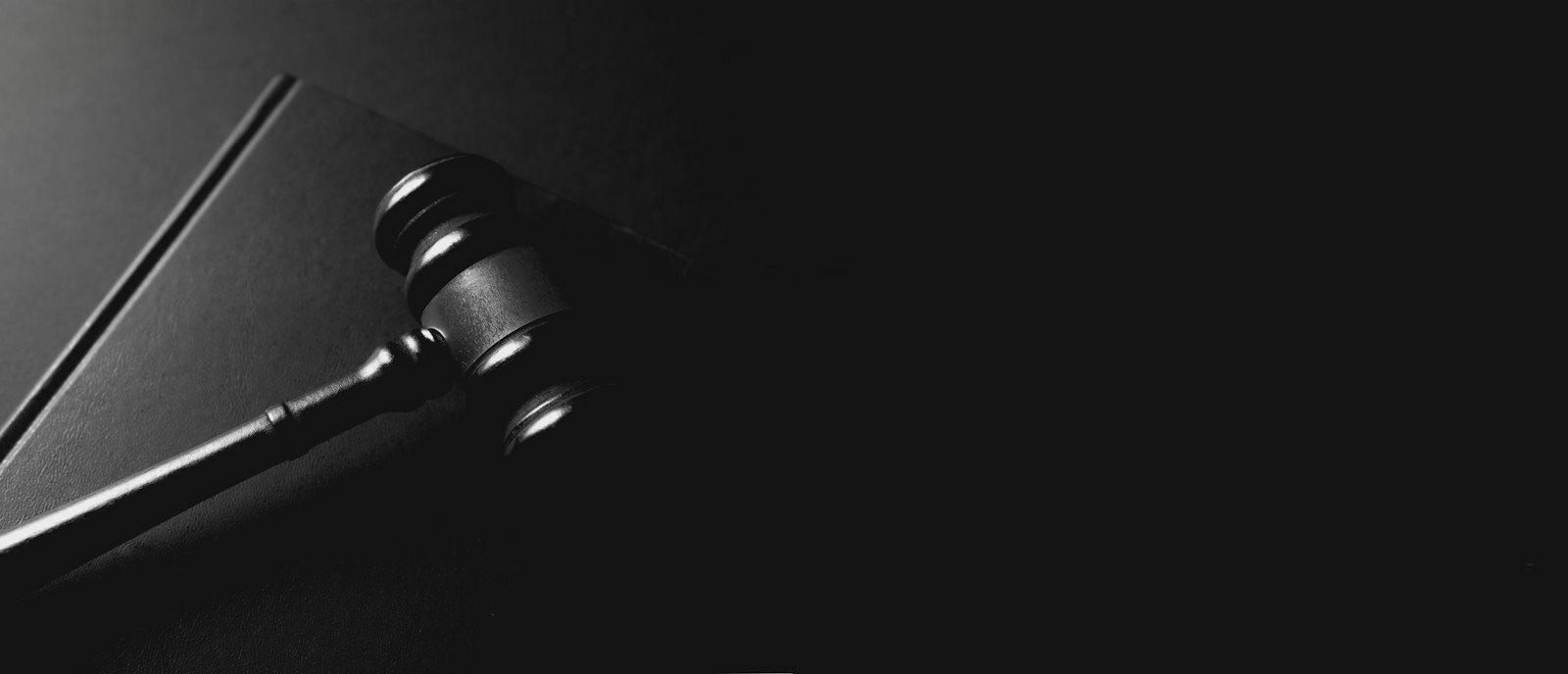 A gavel rests on a dark background