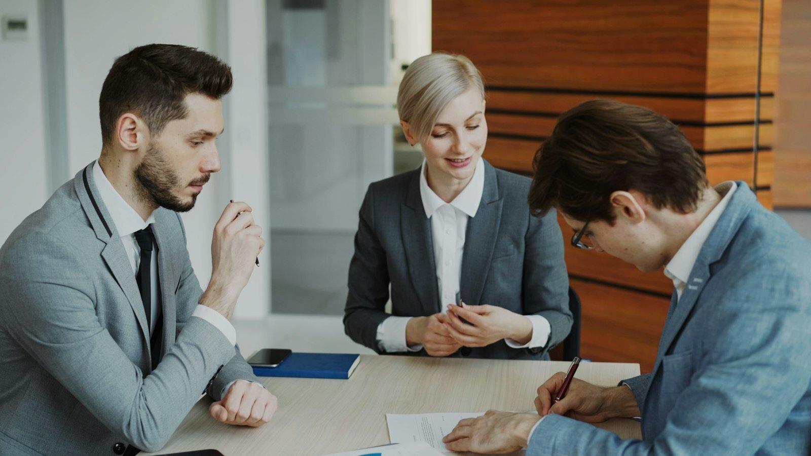 Business people signing a contract at a table